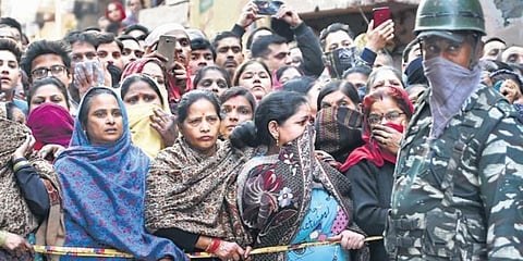 Neighbours gather outside the house in Bhajanpura where five members of a family were found dead on Wednesday. (Photo| EPS)