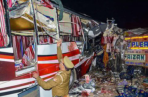 Policeman inspects the mangled remains of a private bus which collided with a truck on the Agra-Lucknow Expressway, in Firozabad. (Photo | PTI)
