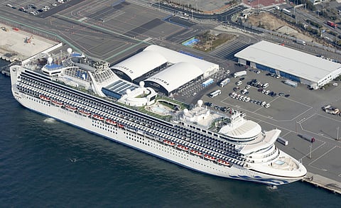 US-operated ''Diamond Princess ship is anchored as emergency vehicles stand by at Yokohama Port, near Tokyo. (photo| AP)