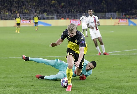 Dortmund's Erling Braut Haaland fights for the ball will PSG goal keeper Keylor Navas during the Champions League round of 16 first leg. (Photo | AP)