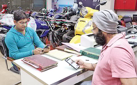 An automobile shop owner keeps track of the Budget 2020 in Bhubaneswar on Saturday. (Photo| Irfana, EPS)