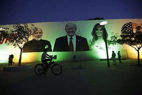 People look at a giant hoarding welcoming U.S. President Donald Trump in Ahmedabad, India, Saturday, Feb. 22, 2020. (Photo | AP)