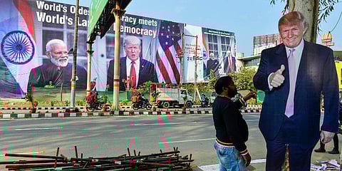 A worker arranges billboards of US President Donald Trump near Taj Mahal ahead of his maiden visit to India in Agra. (Photo| PTI)