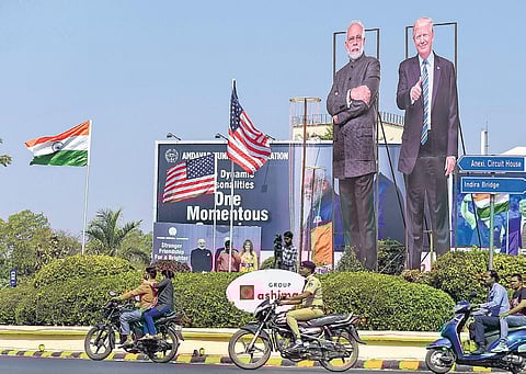 Bikers ride past life-size cut-outs of PM Narendra Modi and US President Donald Trump in Ahmedabad on Sunday | PTI