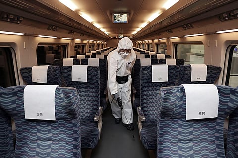 A worker wearing protective gears sprays disinfectant as a precaution on a train against the new coronavirus at Suseo Railway Station in Seoul, South Korea, Tuesday, Feb. 25, 2020. (Photo | AP)