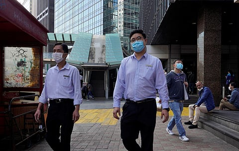 People wearing face masks walk on a street in Hong Kong Tuesday, Feb. 25, 2020. (Photo | AP)