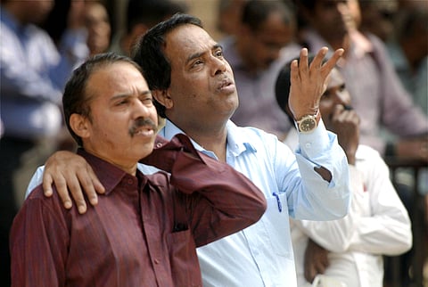People react while watching the stock prices at a screen on the facade of the Bombay Stock Exchange in Mumbai. (File | EPS)