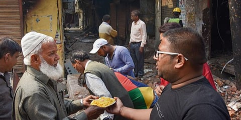 NGO workers distribute food to riot-affected victims following clashes over CAA in North-East Delhi. (Photo| PTI)