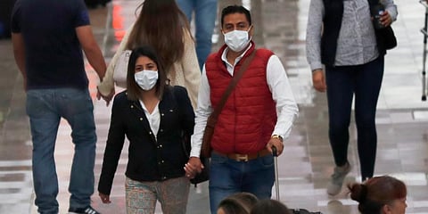 A couple wears protective masks as a precaution against the spread of the new coronavirus at the airport in Mexico City. (Photo | AP)
