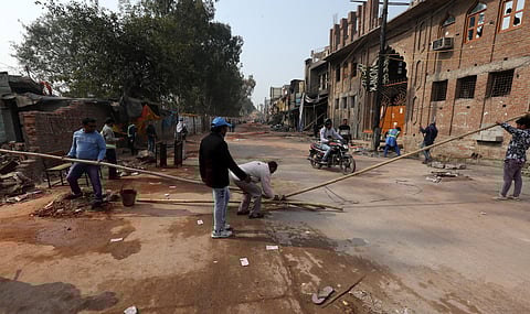 Workers remove debris in a riot-affected area following clashes between people demonstrating for and against a new citizenship law at shiv Vihar area in New Delhi on Friday. (Photo | Shekhar Yadav/EPS)