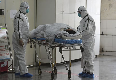 Medical workers in protective suits move a coronavirus patient into an isolation ward at the Second People's Hospital in Fuyang in central China's Anhui Province, Saturday, Feb. 1, 2020. (Photo | AP)