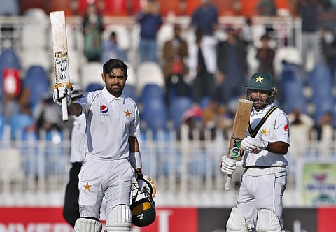 Pakistan batsman Babar Azam celebrates after completing his century as his teammate Asad Shafiq claps. (Photo | AP)