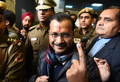 Delhi Chief Minister Arvind Kejriwal shows their ink-marked fingers after voting at a polling station in New Delhi on Saturday. (Photo | Parveen Negi/EPS)