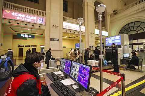 A worker monitors display screens for infrared thermometers as they check travelers at Hankou Railway Station in Wuhan in southern China's Hubei province before authorities seals the city. (Photo | AP)