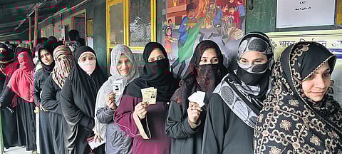 Women show voting cards as they stand to cast votes. (Photo | Parveen Negi, EPS)