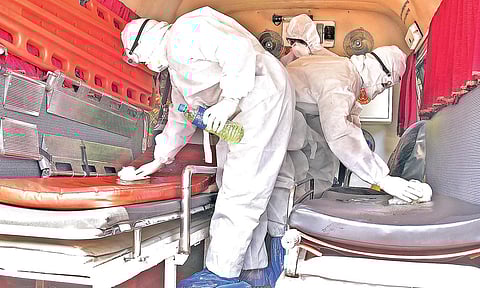 The ambulance that ferried two  patients who tested positive for COVID-19 infection from Pathanamthitta General Hospital to Kottayam Medical College Hospital, being sanitised by nurses and the driver after its return on Monday | Shaji Vettipuram