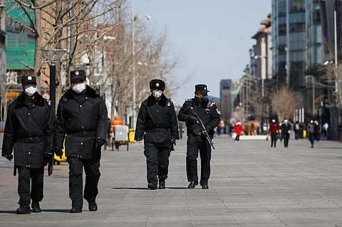Security guards and policemen wearing protective face masks patrol a quiet Wangfujing shopping district following a new coronavirus outbreak in Beijing. (Photo | AP)