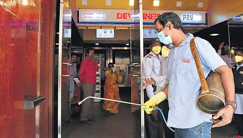 Chennai corporation workmen sanitise Devi Theatre on Mount Road as a part of COVID-19 precautionary measures on Tuesday | m pooja shruthy