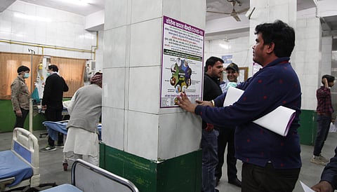 A hospital staff pastes Coronavirus precautions in emergency ward at Bara Hindu Hospital in Delhi On wednesday. (Photo | Anil Shakya/EPS)