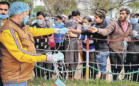 A volunteer distributes masks to people as a preventive measure  in Jammu | Pti