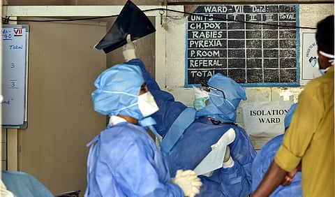 Medical officials in protective suits check medical reports outside an isolation ward of Government Fever Hospital in Hyderabad Friday. (Photo | PTI)