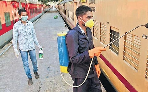 Railway staff spraying disinfectant on coaches as a precaution against COVID-19 at Coimbatore Railway Station on Thursday | A RAJA CHIDAMBARAM