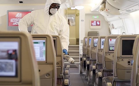 A handout image provided by Emirates airlines on March 8, 2020 in Dubai shows a member of the cleaning staff spraying disinfectant aboard an Emirates Airbus A380-800 aircraft for sterilisation efforts against COVID-19 coronavirus disease. (Photo | AFP)