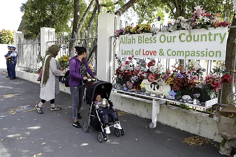 A woman prepares to lay flowers outside the Al Noor mosque in Christchurch, New Zealand. (Photo | AP)