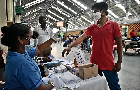 Health team of helpdesk for COVID-19 checks the tempareture of a passenger at Egmore Railway Station on Sunday in Chennai. (Photo | P Jawahar/EPS)