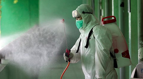A member of Indonesian Red Cross sprays disinfectant in the wake of coronavirus outbreak at a school in Jakarta, Indonesia