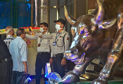 Security personnel use thermal screening devices on visitors to mitigate the coronavirus pandemic, at BSE Building in Mumbai. (Photo | PTI)