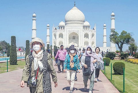 Tourists wearing protective masks at the Taj Mahal in Agra on Monday. (Photo| PTI)