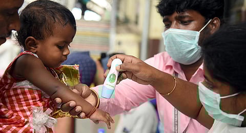 Help desk for COVID-19 checks the tempareture of a child at Egmore railway station. (Photo | Martin Louis, EPS)