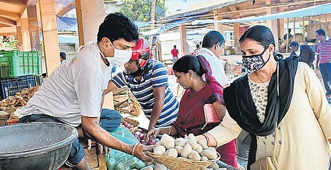 Wearing masks, people buy vegetables at a market in Bhubaneswar. (Photo | Biswanath Swain, EPS)