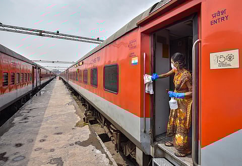 A railway worker sprays disinfectant on Howrah-New Delhi Rajdhani Express train in the wake of coronavirus pandemic at a railway yard in Kolkata Monday March 16 2020. (Photo | PTI)
