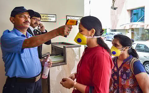 An official uses thermal screening device on visitors at a city hotel in the wake of coronavirus pandemic in Kolkata Tuesday March 17 2020. (Photo | PTI)
