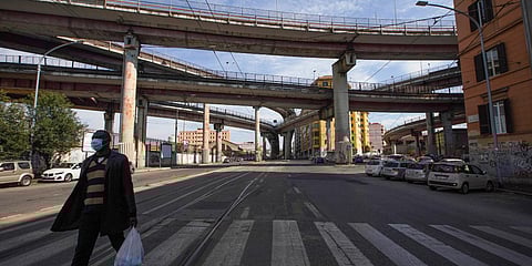 A man wears a protective mask as he walks in an empty street, in Rome. (Photo| AP)