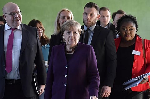 German Chancellor Angela Merkel (C), German Economy Minister Peter Altmaier (L) and Sylvie Nantcha (R), head of The African Network of Germany (TANG), arrive to give a press conference at the end of a summit on integration at the Chancellery in Berlin. (P