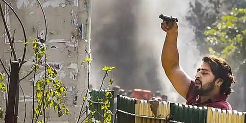 A protestor brandishes a pistol during clashes between two groups at Jafrabad in Northeast Delhi. (Photo | PTI)