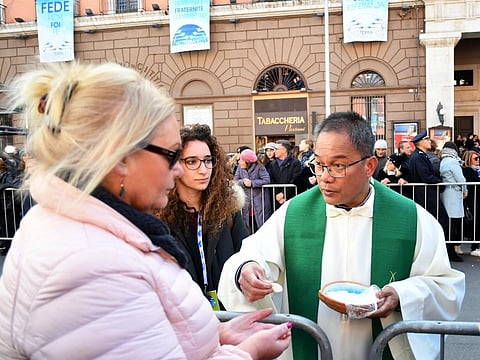 A priest gives communion during a Pope's visit to Bari, southern Italy. (Photo | AFP)