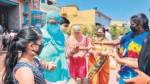 Devotees apply sanitisers on  hands before entering Jagannath temple at Puri I Ranjan