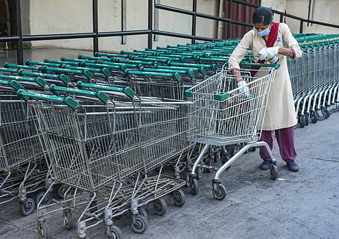 A worker sanitizes trolleys at a store as a precautionary measure to prevent the spread of coronavirus in Surat Thursday March 19 2020. (Photo | PTI)