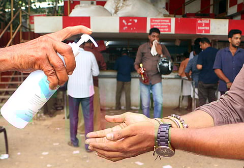 The buyers are given hand rub sanitizers to clean their hands in front of beverage outlet at Eranjipalam to prevent spread of COVID-19. (Photo | TP Sooraj/EPS)
