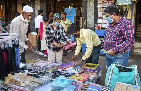People wearing masks as a preventive measure in the wake of coronavirus pandemic shop from a roadside stall at Abdul Rahman Street in Mumbai Thursday March 19 2020. (Photo | PTI)