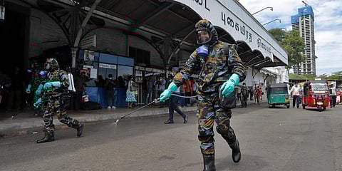 Sri Lankan government soldiers in protective clothes spray disinfectants at a railway station in Colombo. (Photo| AP)