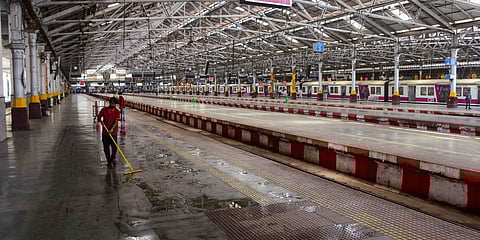 Cleaning staff members mop a platform of CSM Terminus in the wake of deadly coronavirus in Mumbai. (Photo| PTI)