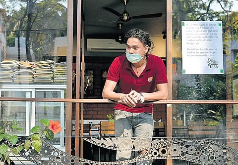 With only hotel kitchens being allowed to remain open for takeaways, an employee of a cafe at Indiranagar in Bengaluru waits for orders on Saturday | Meghana Sastry