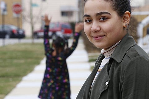 Jalen Grimes smiles as her 7-year-old sister, Sydney, prepares for a cartwheel outside their home in Chicago on Sunday (Photo | AP)