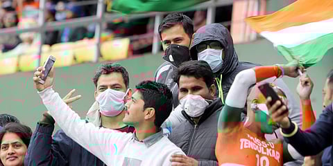 Cricket fans wearing facemasks amid concerns of the spread of coronavirus, as they wait for the start of the first ODI match between India and South Africa at Dharamsala. (Photo| ANI)