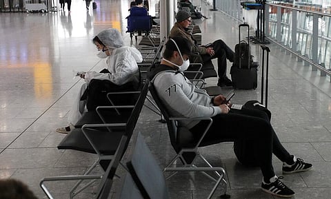 Travellers wear face masks as they wait at Heathrow Airport in London, Wednesday, March 18, 2020. (Photo | AP)